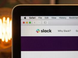 Das Slack-Logo vor einfarbigem Hintergrund, deutlich sichtbar und zentriert, als Symbol für digitale Teamkommunikation abgebildet.
