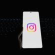 Ein Smartphone mit dem Instagram-Logo, platziert auf einer Computertastatur – Symbol für Social Media Nutzung im Arbeitsumfeld.