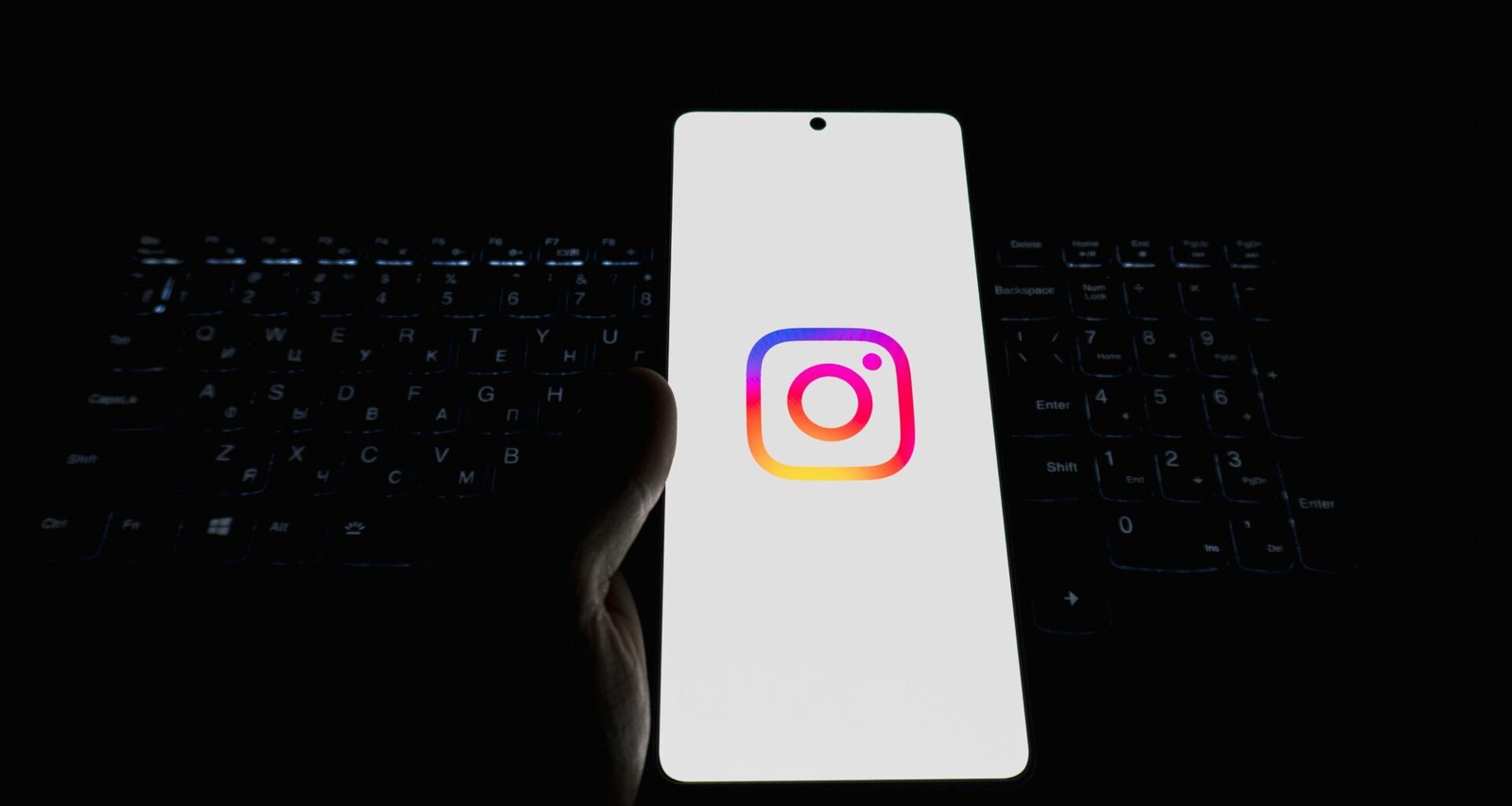 Ein Smartphone mit dem Instagram-Logo, platziert auf einer Computertastatur – Symbol für Social Media Nutzung im Arbeitsumfeld.