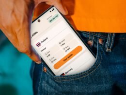 Ein Smartphone steckt in einer Jackentasche und zeigt Reiseinformationen auf dem Display an.