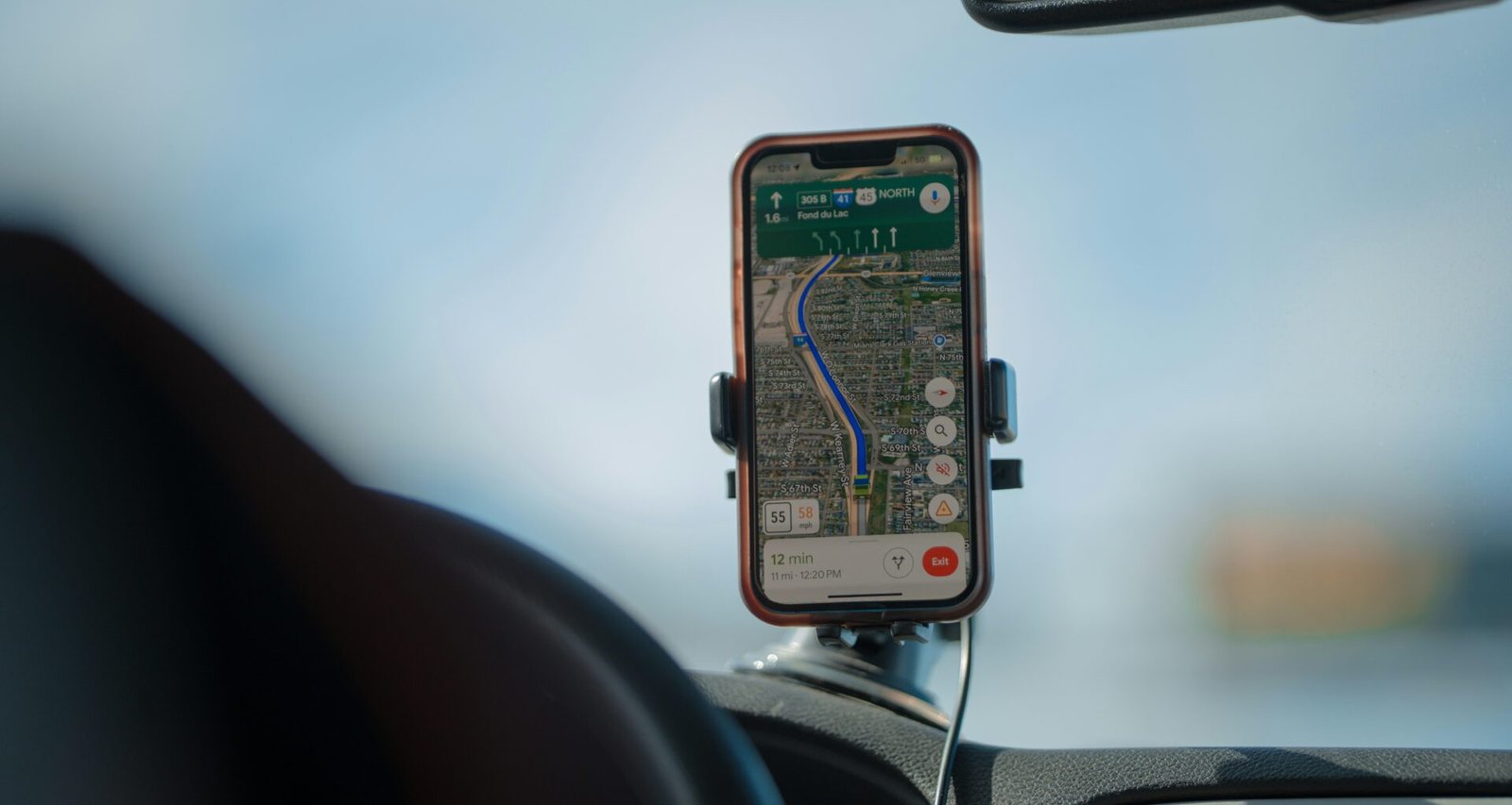 Smartphone mit Navigations-App auf dem Armaturenbrett eines Autos, das eine geplante Route anzeigt, moderne Navigationstechnologie