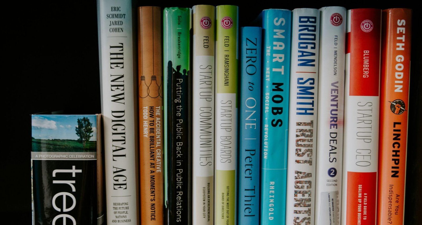 Verschiedene aufgestapelte Bücher mit bunten Einbänden, aufgenommen als Symbol für Wissen und Weiterbildung im digitalen Bereich.