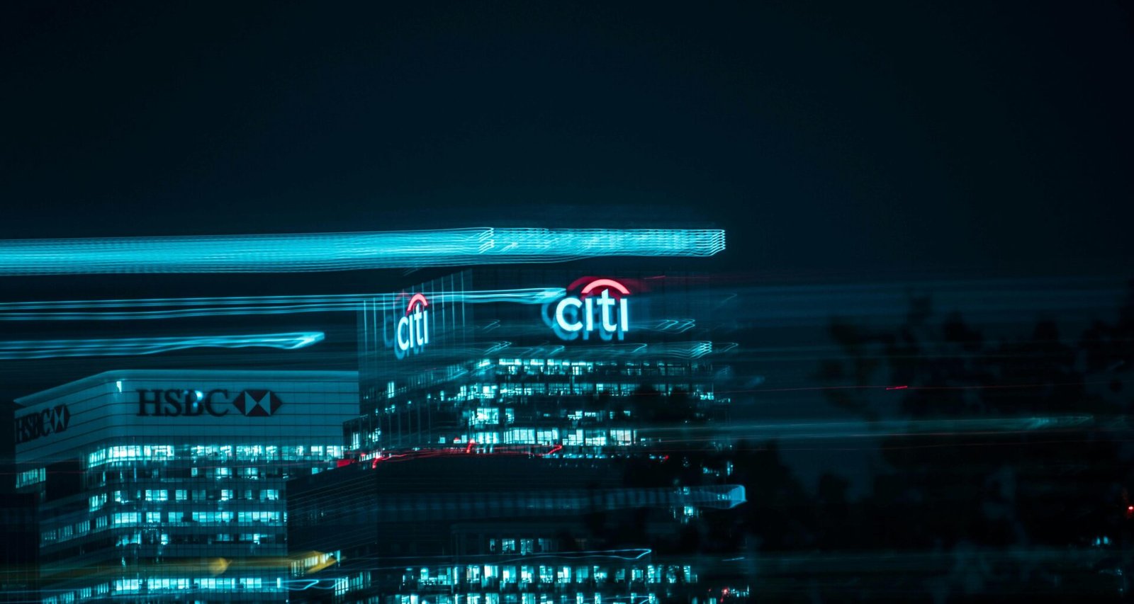 Stadtgebäude mit leuchtenden Fenstern und Lichtern bei Nacht, urbanes Stadtbild mit moderner Ausstrahlung.