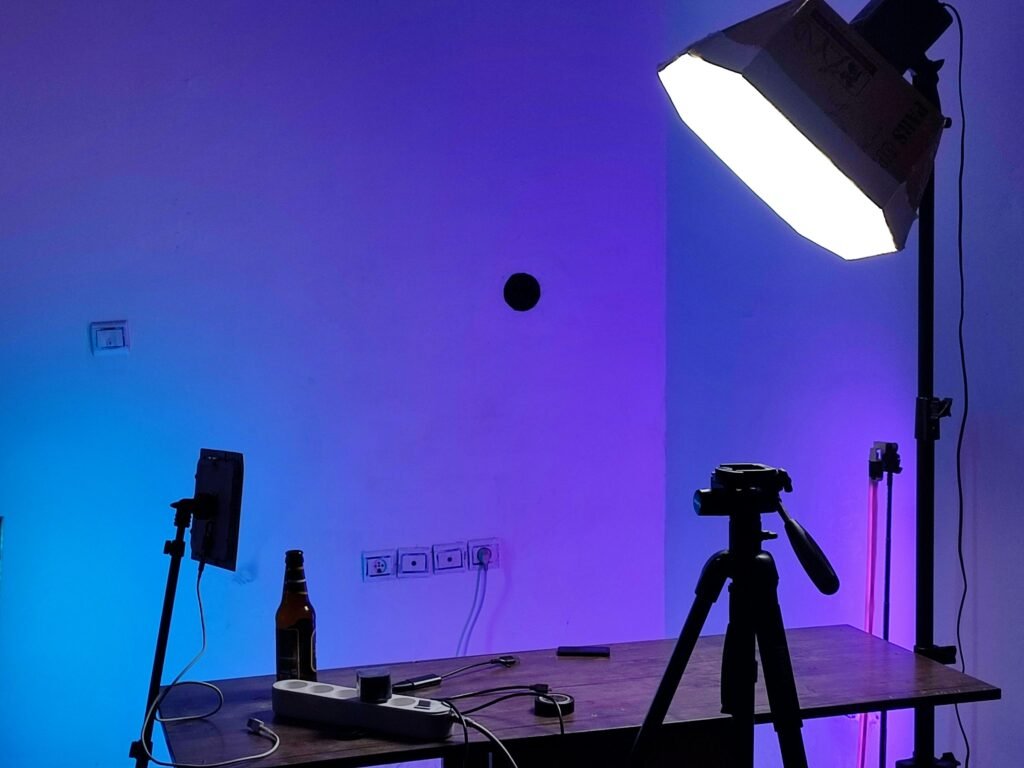 Studioeinrichtung mit professioneller Beleuchtung, Kamera auf Stativ und einem Tisch, ideal für Foto- oder Videoaufnahmen.