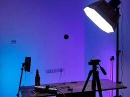 Studio-Setup mit professioneller Beleuchtung, Kamera auf Stativ und Tisch, geeignet für Filmproduktion oder Webinare.
