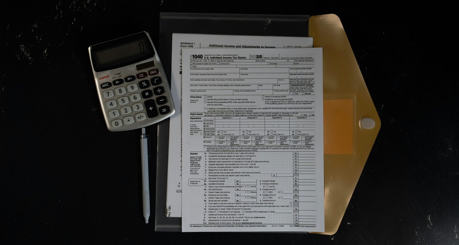 Taschenrechner und Papierunterlagen in einem geöffneten Ordner auf einer dunklen Oberfläche, passend für Buchhaltung oder Organisation.