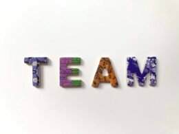 Freistehende Buchstaben bilden das Wort TEAM und stehen auf heller Oberfläche, passend zum Thema Zusammenarbeit.