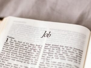 Auf einem Schreibtisch liegen Laptop, Notizbuch und Stift – Sinnbild moderner Arbeitsweise im Büroalltag.