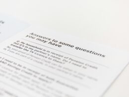 Offener Laptop neben Smartphone und Notizbuch auf einem Schreibtisch, passend zum Thema Online-Marketing