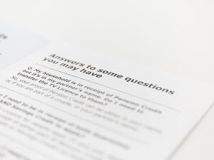 Offener Laptop neben Smartphone und Notizbuch auf einem Schreibtisch, passend zum Thema Online-Marketing