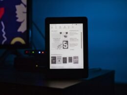 Ein aufgeräumter Schreibtisch mit offenem Laptop, Notizbuch und Kaffeetasse im modernen Büroambiente