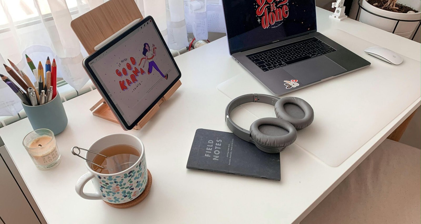 Weiße und blaue Keramiktasse neben einem schwarzen Laptop auf einem weißen Arbeitstisch im modernen Büro