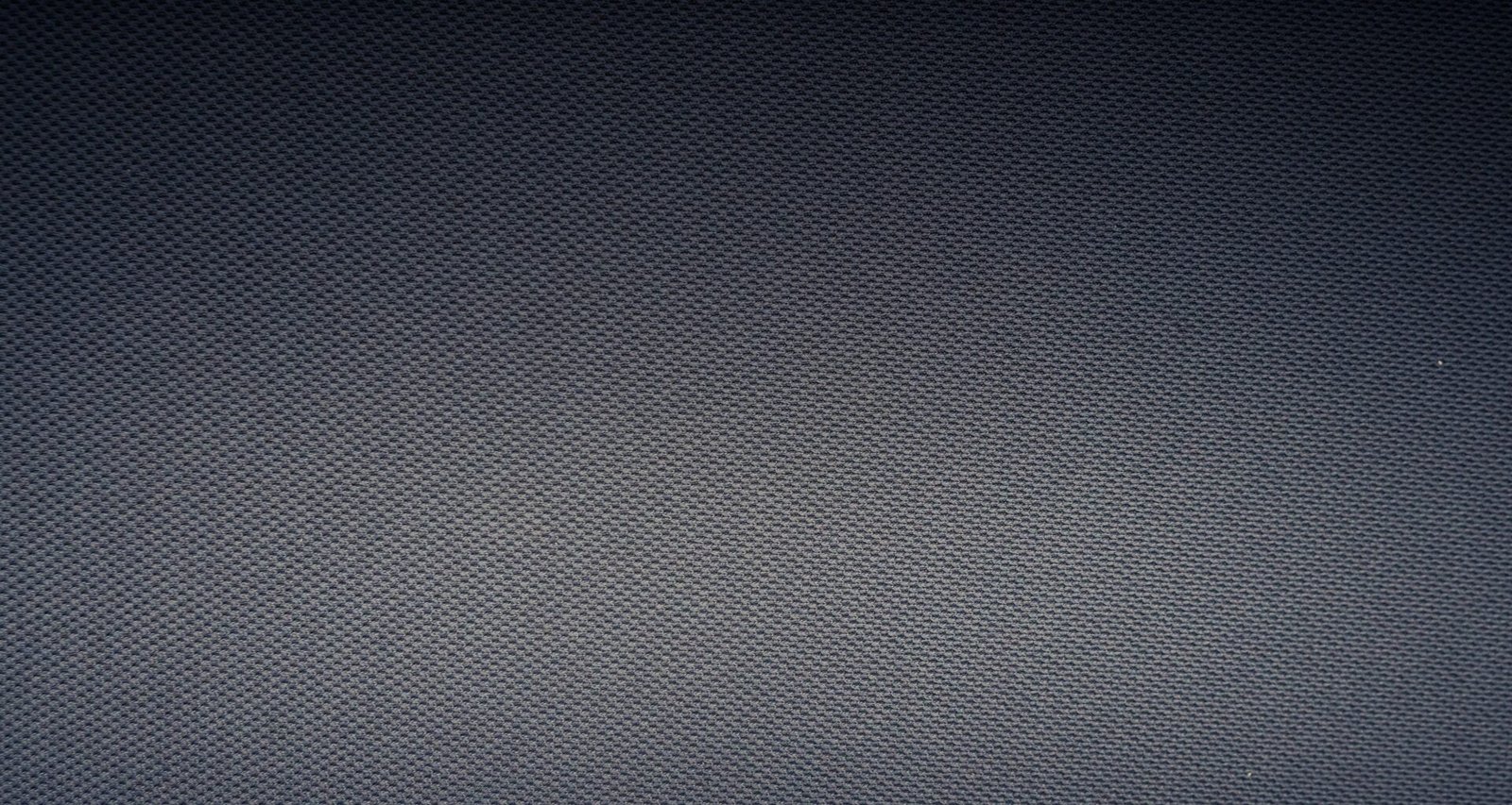 Nahaufnahme eines weiß-grau karierten Textils, das die feine Webstruktur und das Schachbrettmuster deutlich zeigt