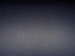 Nahaufnahme eines weiß-grau karierten Textils mit klaren Linien und weicher Stoffstruktur im Detail