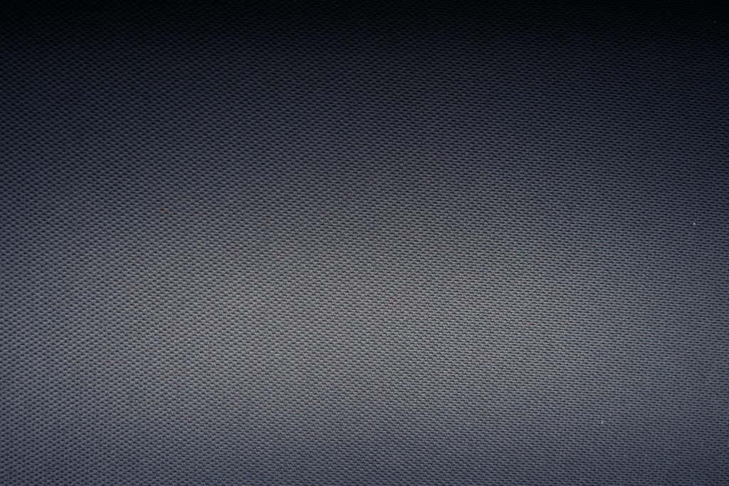 Nahaufnahme eines weiß-grau karierten Textils mit feiner Webstruktur, geeignet zur Illustration von Design- oder Materialthemen