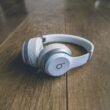 Weiße kabellose Beats by Dr. Dre Kopfhörer liegen auf einem schlichten Untergrund, Nahaufnahme der modernen Kopfhörer