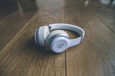 Weiße kabellose Beats by Dr. Dre Kopfhörer liegen auf einem schlichten Untergrund, Nahaufnahme der modernen Kopfhörer