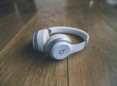 Weiße kabellose Beats by Dr. Dre Kopfhörer liegen auf einem schlichten Untergrund, Nahaufnahme der modernen Kopfhörer