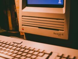 Weiße Computertastatur auf schwarzem Tisch, Detailaufnahme mit Fokus auf klare Tasten und modernes Design