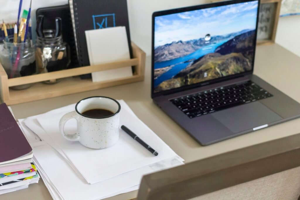 Weiße Keramiktasse auf weißem Tisch, aufgenommen von Bennett Frazier; minimalistisches Setting für Büro oder Homeoffice