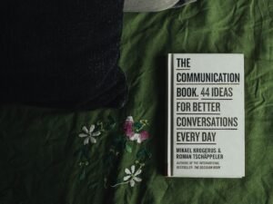 Zwei schlichte schwarze und weiße Boxen auf grün-weiß gemustertem Flachgewebe mit floralem Design