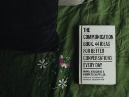 Weiße und schwarze Box auf grün-weißem Textil mit floralen Mustern als modernes Deko-Element