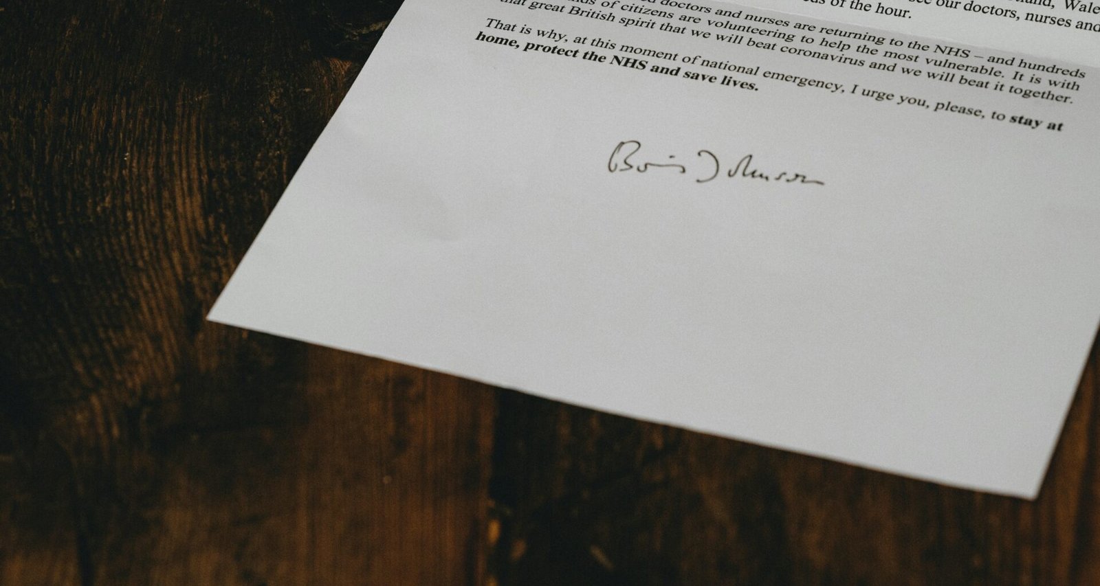 Weiße Druckerblätter liegen ordentlich auf einem braunen Holztisch, geeignet für Büro- und Organisationsthemen.