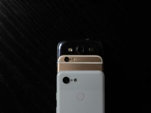 Weißes iPhone 4 liegt auf schwarzem Stoff, modernes Smartphone als klassisches Technikbeispiel