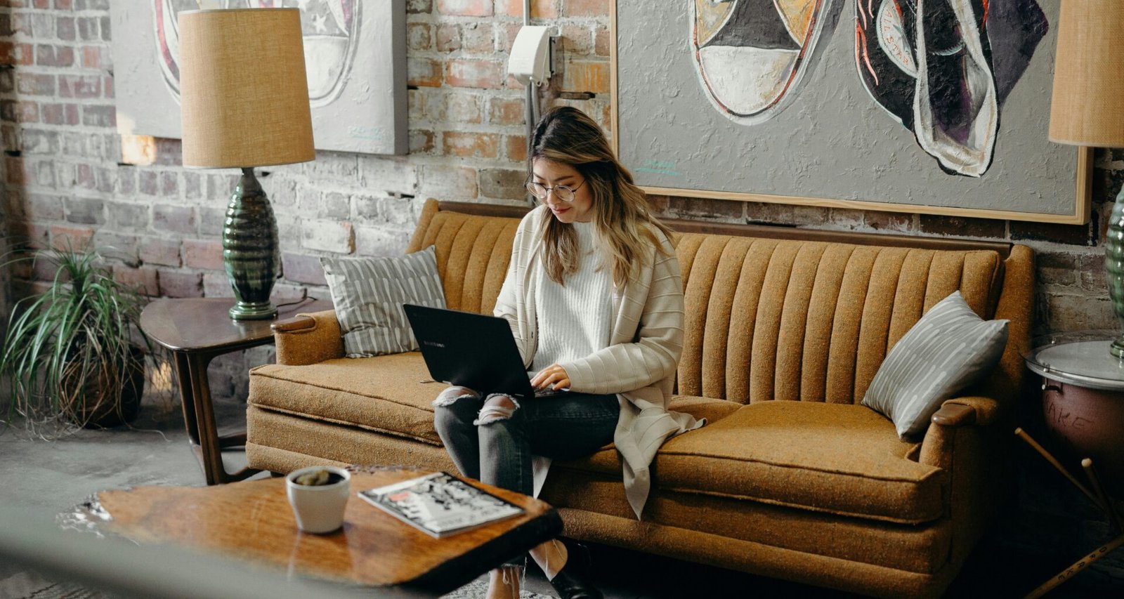 Frau sitzt auf einem Stuhl und arbeitet am Laptop, typische Szene im digitalen Arbeitsplatz oder Homeoffice.