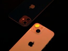 Zwei nebeneinanderliegende iPhones auf einem Tisch, Fokus auf modernes Smartphone-Design und Technik.