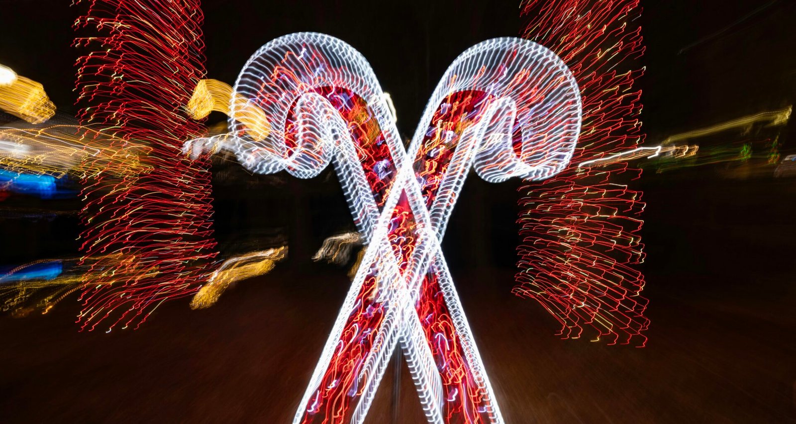Zwei leuchtende Zuckerstangen mit roten Lichtern vor dunklem Hintergrund, fotografiert von Mick Haupt