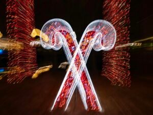 Zwei leuchtende Zuckerstangen mit roten Lichtern vor dunklem Hintergrund, fotografiert von Mick Haupt